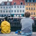 women between two men sitting beside river