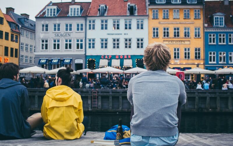 women between two men sitting beside river