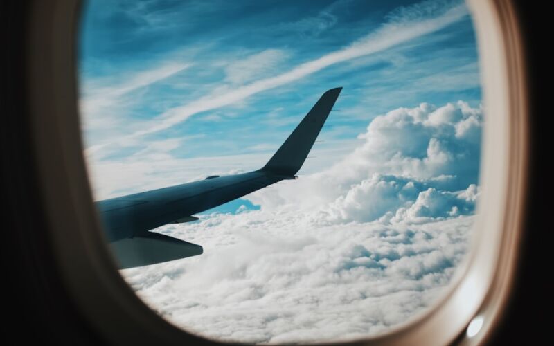 person taking picture of plane wings while flying during daytime